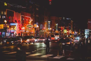 View of Lower Broadway, downtown Nashville, TN at night with neon signs brightly lit.